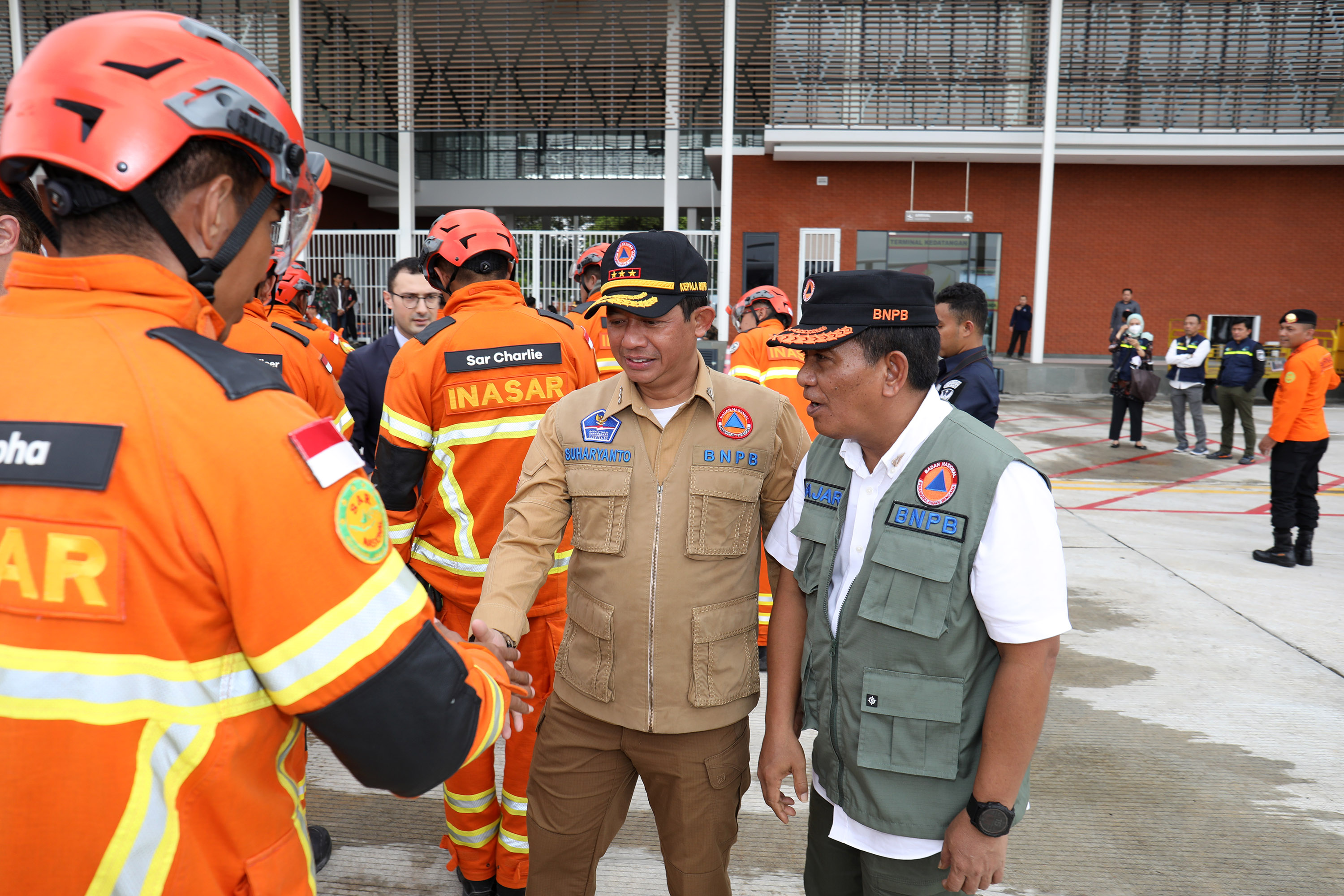 Kepala BNPB Letjen TNI Suharyanto S.Sos., M.M., (rompi colekat) menyalami salah satu personel usai melaksanakan misi kemanusiaan untuk Turkiye di Lanud Halim Perdanakusuma, Jakarta, Jumat (24/2).